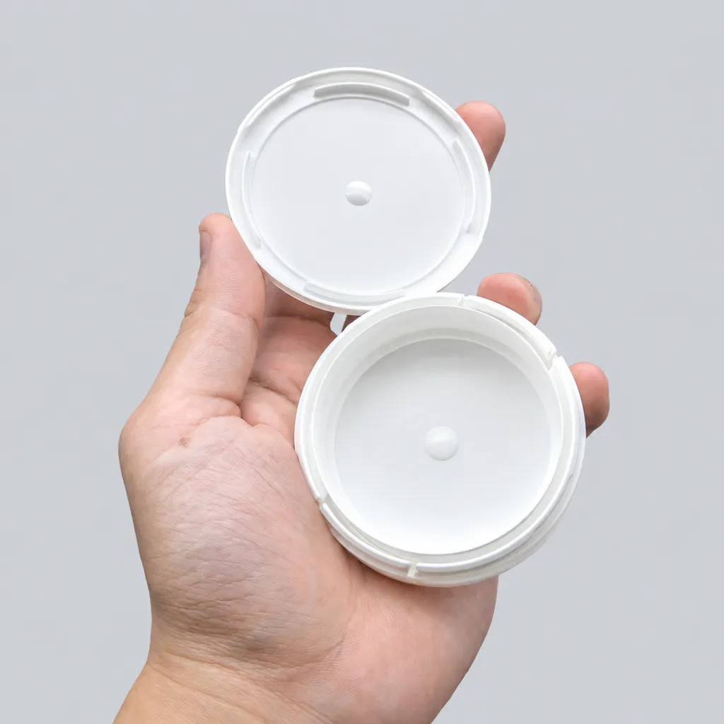 Hand holding an open white child-resistant snus can with the locking-tab rim visible